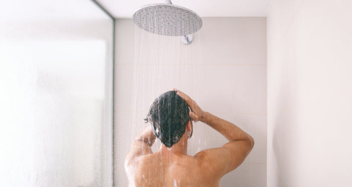 Mann wäscht seinen Körper mit ph-neutralem Duschgel