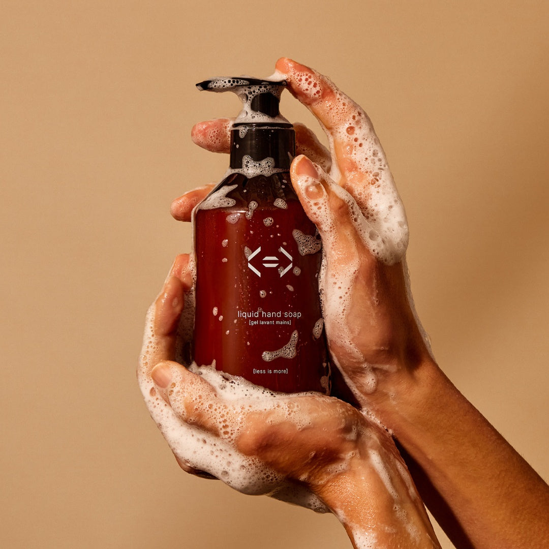 hands holding liquid hand soap less is more